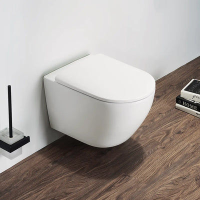 Wall-mounted white toilet in a bathroom with wooden floor and cleaning brush