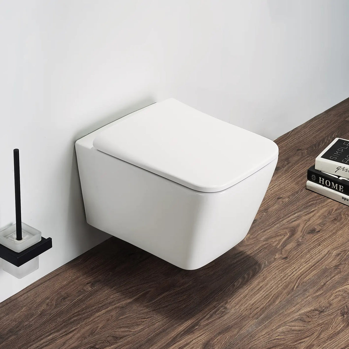 White wall-mounted toilet in a bathroom with wooden floor and cleaning brush