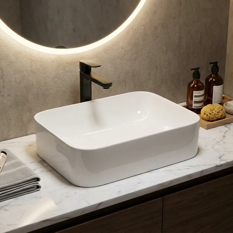 Bathroom vanity with a white sink, faucet, and toiletries on a marble countertop.